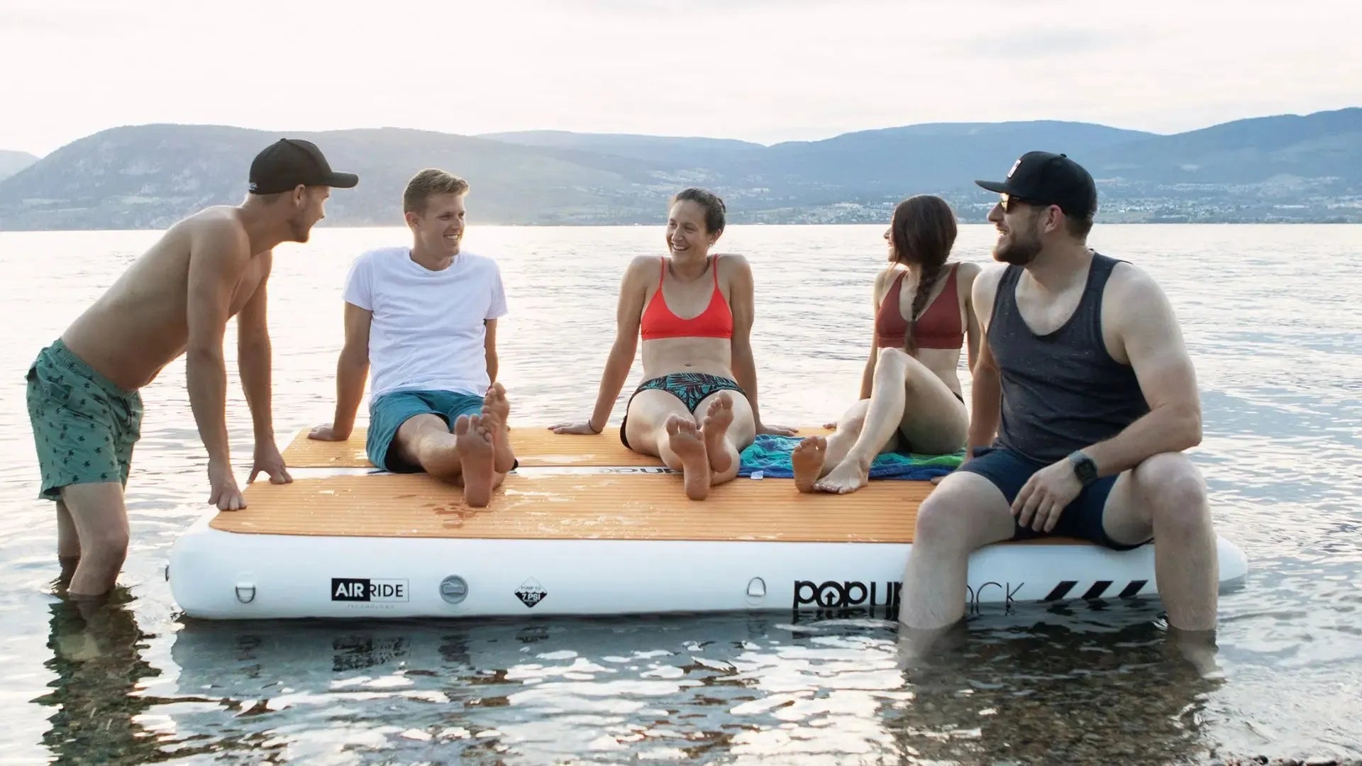 Inflatable popup dock with group enjoying lake swimming platform