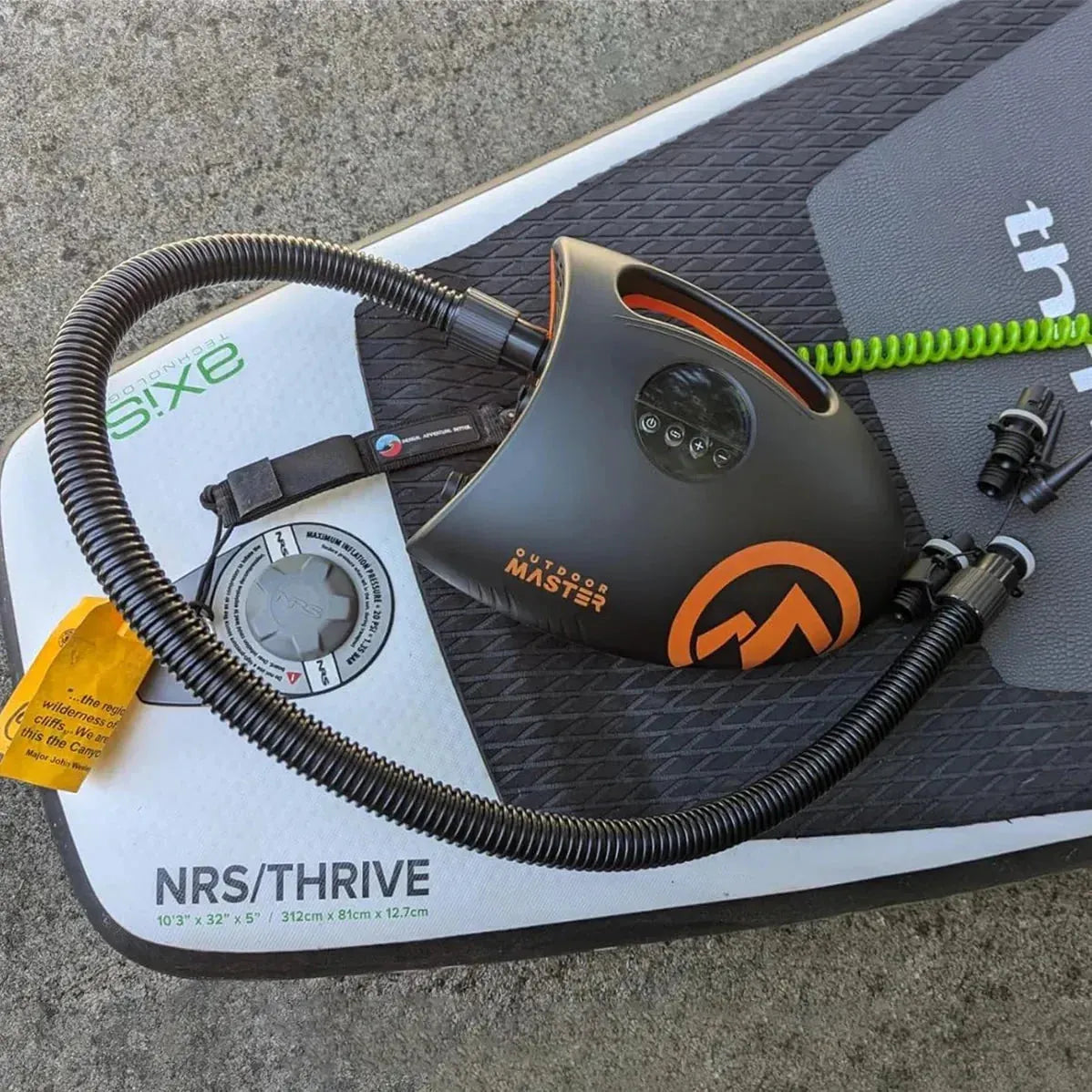 Outdoor Master Shark 2S electric pump with hose resting on a paddleboard